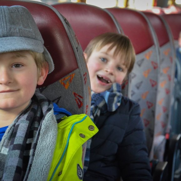 Kinderen in schoolbus die autogordel dragen