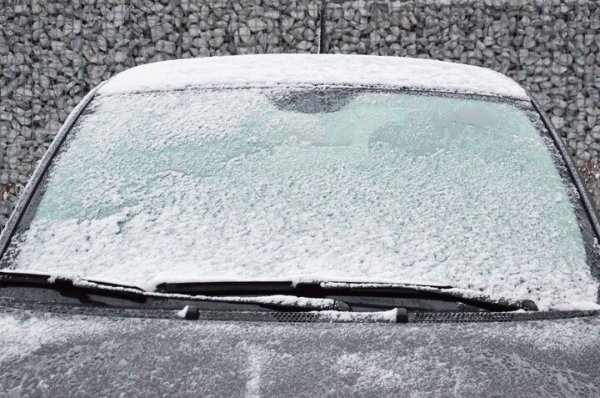 geparkeerde auto met besneeuwde voorruit