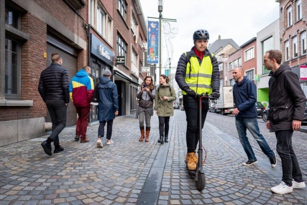 man op e-step in winkelstraat