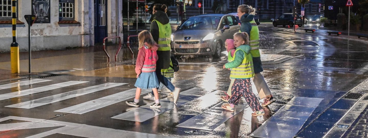 voetgangers in fluohesjes die oversteken op een zebrapad