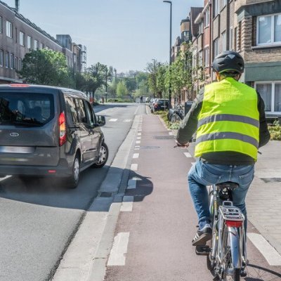 auto die pinkt om rechts af te slaan, fietser op een fietspad 