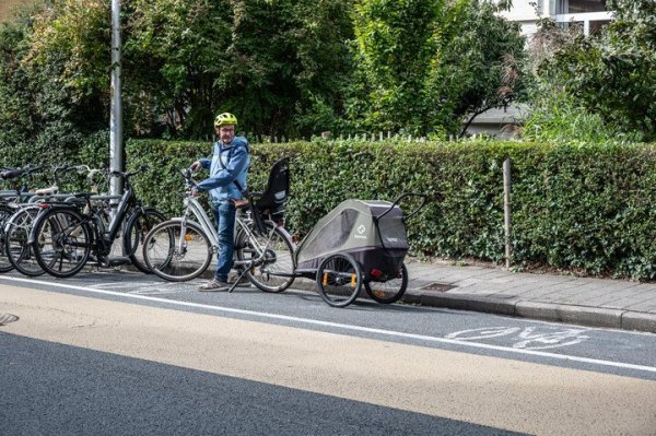 Man met fiets met fietkar in een geschilderd fietsparkeervak