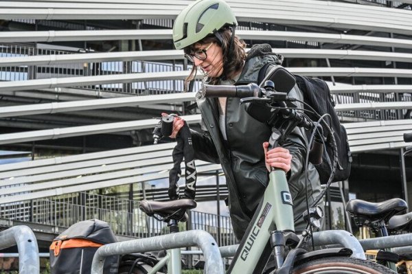 Vrouw die fiets op slot legt met groot kettingslot