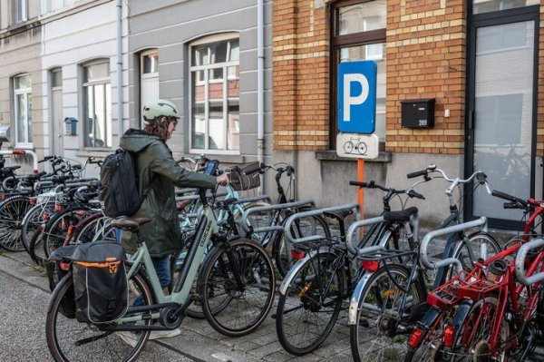 Vrouw die fiets in fietsenrek zet
