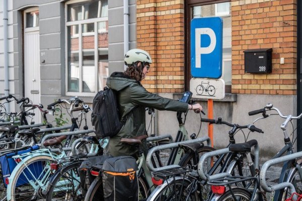 Vrouw die fiets in rek zet