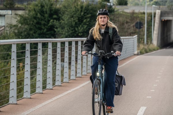 jonge vrouw op fietsbrug met fietshelm op