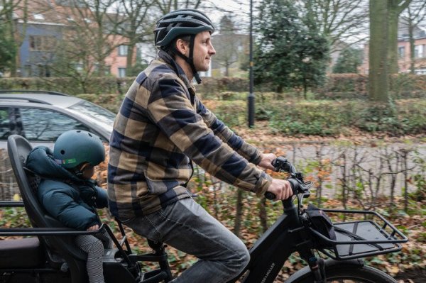 man die fietst met longtail, kind achterop in fietsstoel