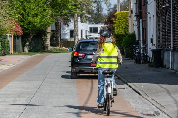 Fietser die een geparkeeerde auto moet voorbijrijden op een fietssuggestiestrook
