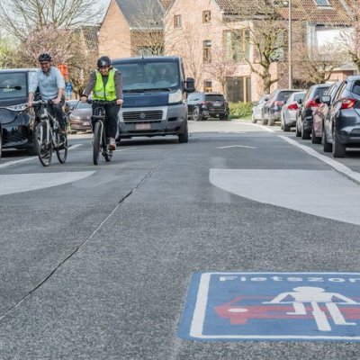 2 fietsers met auto achter hen in fietszone