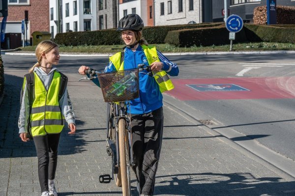 Kinderen met fiets aan de hand op een voetpad