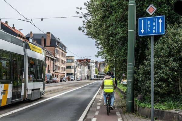 fietser op een fietspad in een straat met vrije trambedding waar tram rijdt