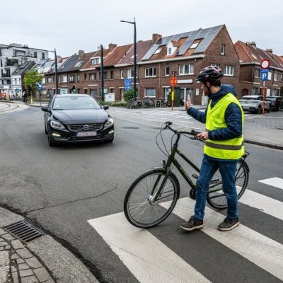 fietser steekt hand op naar automobilist die voorrang geeft aan zebrapad