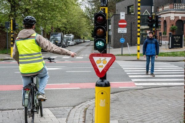 fietser bij verkeerslicht, slaat rechtsaf, voetganger steekt over