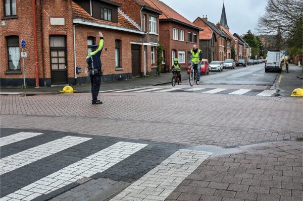 agent die arm omhoog houdt, op kruispunt